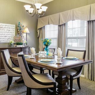 Elegantly decorated dining room with a wooden table set and upholstered chairs.