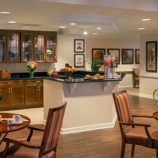 A cozy dining and kitchen area with warm lighting and wooden furnishings.