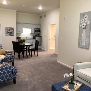 A modern living room with elegant furnishings, featuring a dining area and contemporary decor.