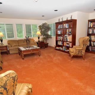 A cozy living room with bookshelves and comfortable seating.