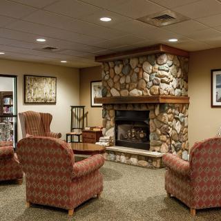 A cozy living room with a stone fireplace and comfortable seating.