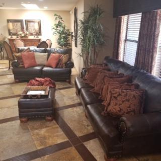A cozy living room setup featuring leather sofas, decorative pillows, and a coffee table.