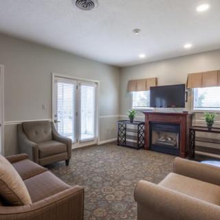 A cozy living room with comfortable seating, a fireplace, and a television.