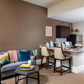 A modern open-concept living room and kitchen with a comfortable sofa, stylish chairs, and a cozy dining area.