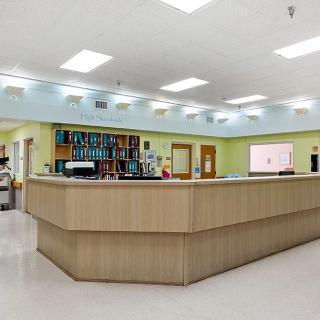 A hospital reception area with a counter and medical staff working.