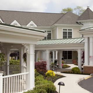 A charming residential building with a well-maintained garden and inviting porch.