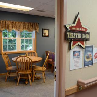 A cozy dining area with wooden furniture and a welcoming sign.