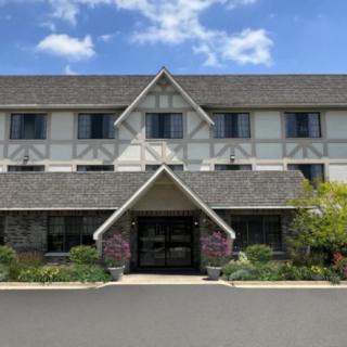A three-story building with a triangular roof and well-maintained landscaping.