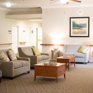 A cozy living room with sofas, coffee tables, and artwork on the wall.