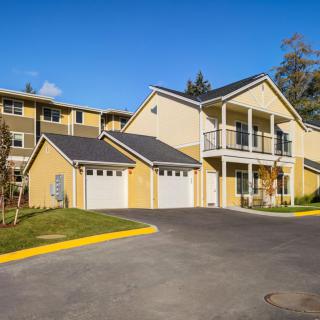 A suburban residential building with garages and a balcony.