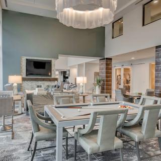 A modern and spacious dining area with contemporary furniture and a stylish chandelier.
