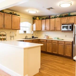 A spacious kitchen with wooden cabinets and stainless steel appliances.