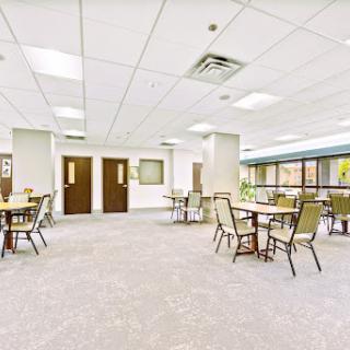 A spacious and inviting dining area featuring tables and chairs, designed for communal gatherings.