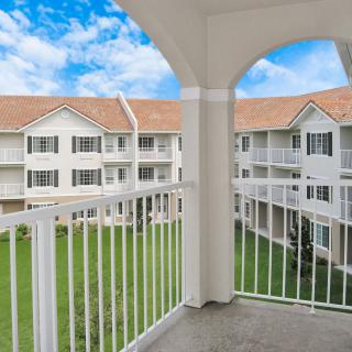 View from a balcony overlooking an apartment complex with a clear blue sky.