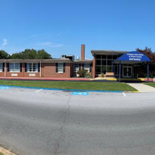 A panoramic view of a school building under a clear blue sky.