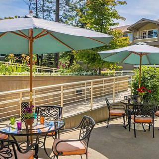A sunny outdoor patio with tables and umbrellas, perfect for relaxation.