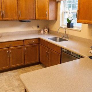 A clean, modern kitchen with wooden cabinets and a spacious countertop.