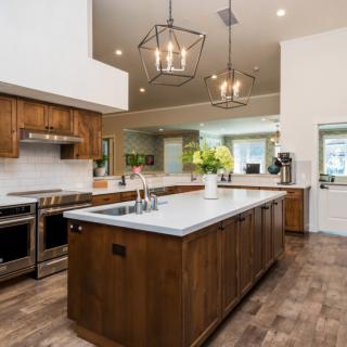 A modern kitchen with wood cabinets, a large island, and stainless steel appliances.