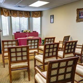 A small indoor ceremony room with arranged chairs and a central table.