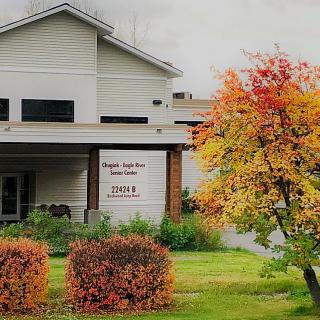 A building with a visible sign and colorful autumn foliage in the foreground.