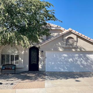 A charming single-family home with a garage and a welcoming front yard on a bright sunny day.