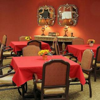 A cozy dining room with red tablecloths and elegant decor.