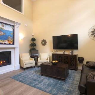 A modern living room featuring a large TV, fireplace, and comfortable seating arrangement.