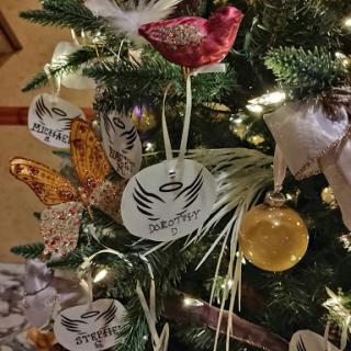 A beautifully decorated Christmas tree adorned with various ornaments including a red bird and butterflies.