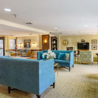 A spacious and elegantly decorated living room with blue sofas, a neutral color palette, and modern furnishings.