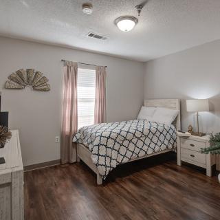 A cozy bedroom with a single bed, nightstand, and decorative elements.