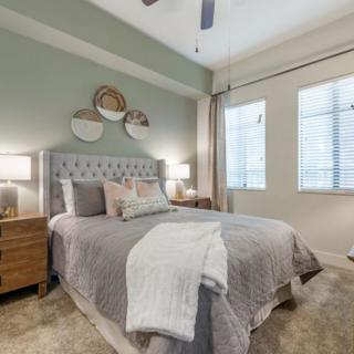 A modern bedroom with a stylish bed, nightstands, and decorative wall art.