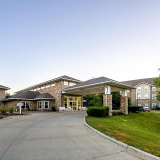 A modern building with a driveway and landscaped surroundings.