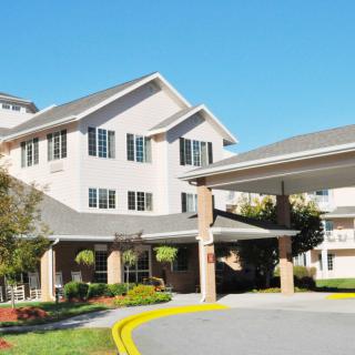 A residential building with a landscaped entrance, likely part of a retirement or senior living community.