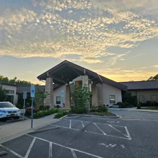 A tranquil view of a building against a stunning sunset sky.