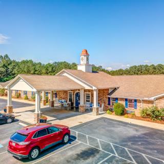 A welcoming community center featuring a well-maintained exterior and ample parking on a sunny day.