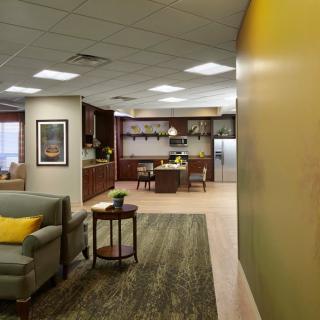 A modern office space with a comfortable seating area and an open kitchen layout.