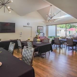 A modern dining area with elegantly set tables and large windows providing natural light.
