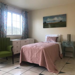 A cozy bedroom featuring a single bed, colorful curtains, and stylish furniture.