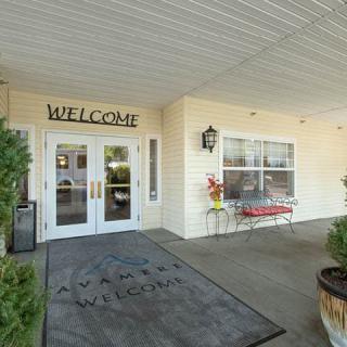 The entrance of a building with a welcome sign above the doors.
