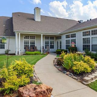 A beautiful backyard with well-maintained landscaping and a pathway leading to the house.