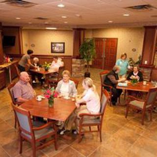 A group of seniors socializing in a dining hall setting.