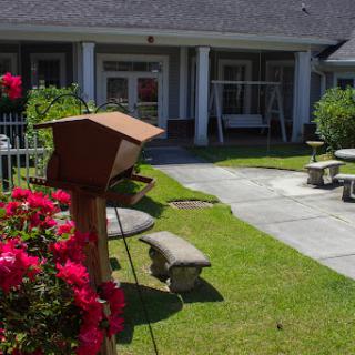 A serene garden area featuring vibrant flowers and comfortable seating, perfect for relaxing.