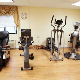 A small gym with various exercise machines, including a stationary bike and elliptical.