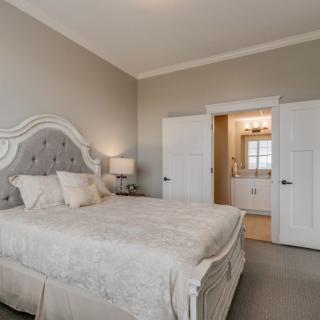 A well-decorated bedroom with elegant furniture and a view into an adjoining bathroom.