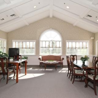 A spacious living room with elegant wooden furniture and large windows.
