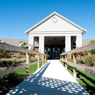 A pathway leading to the entrance of a modern building on a sunny day.