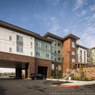 Modern residential apartment building exterior under a clear sky.