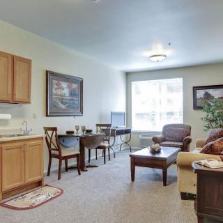 A cozy living room with a kitchenette, featuring comfortable seating and tasteful decor.