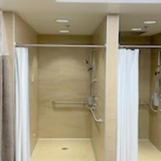 A clean, accessible shower area with curtains and tiled walls.