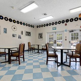 A cozy dining area featuring a nostalgic music theme with record decorations and checkered flooring.